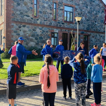 Miera skrējiena dalībnieki un lāpa Sējas skolā - 