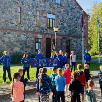 Miera skrējiena dalībnieki un lāpa Sējas skolā - 
