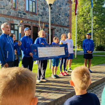 Miera skrējiena dalībnieki un lāpa Sējas skolā - 